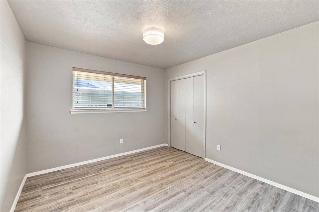 2022 Normandy Drive, Irving, TX 75060 Recessed window with blinds, wood-finish flooring, and bi-fold closet doors
