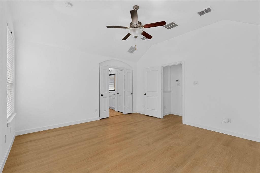 Vaulted ceilings, wood-finish flooring, and a ceiling fan with integrated lighting