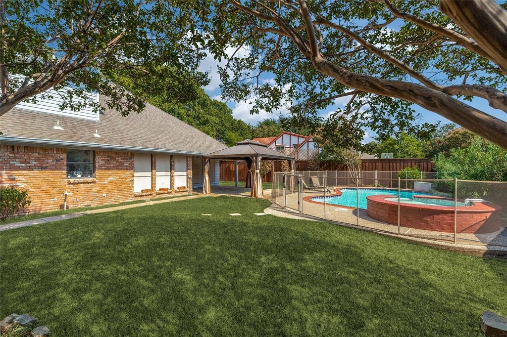 5013 Country Place Drive, Plano, TX 75023 Expansive lawn area with a fenced swimming pool, integrated spa, and an outdoor gazebo