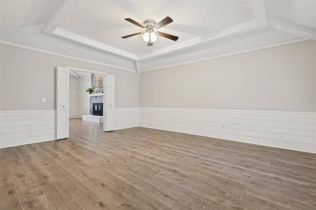 5013 Country Place Drive, Plano, TX 75023 Wood-finish flooring, coffered ceiling, ceiling fan, bi-fold doors, and shiplap wainscoting