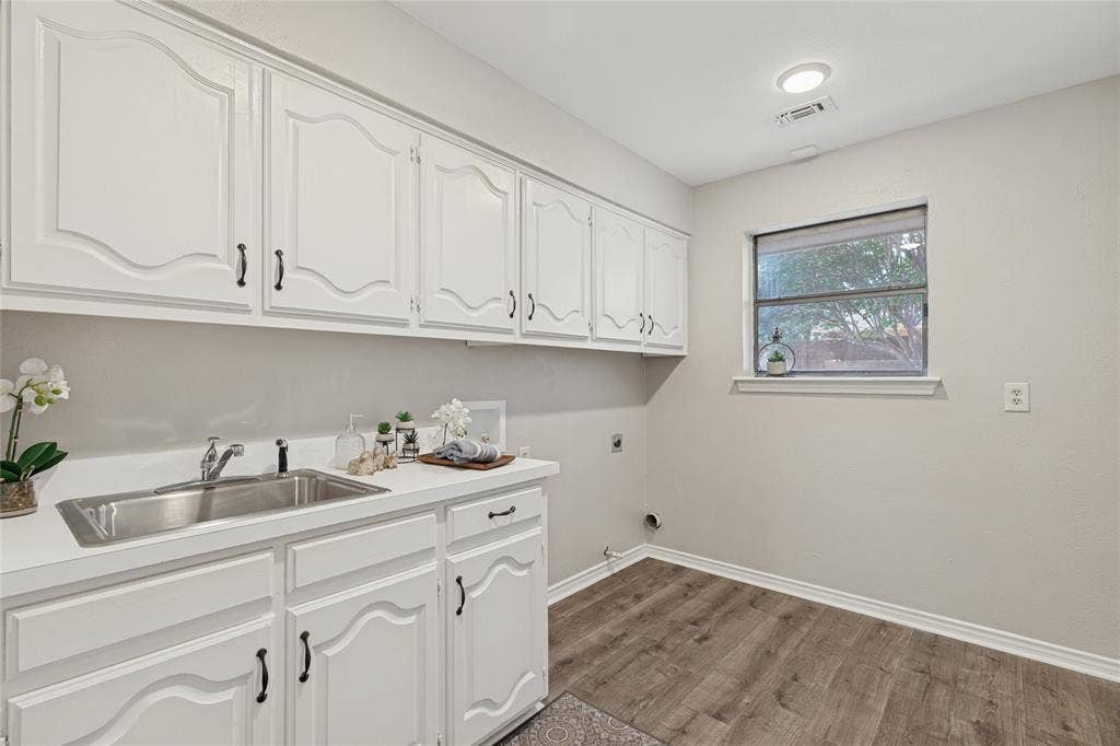 5013 Country Place Drive, Plano, TX 75023 White cabinetry with dark hardware, stainless steel sink, countertop, wood-finish flooring, and recessed lighting, fresh and airy, with plenty of room for a freezer or second refrigerator