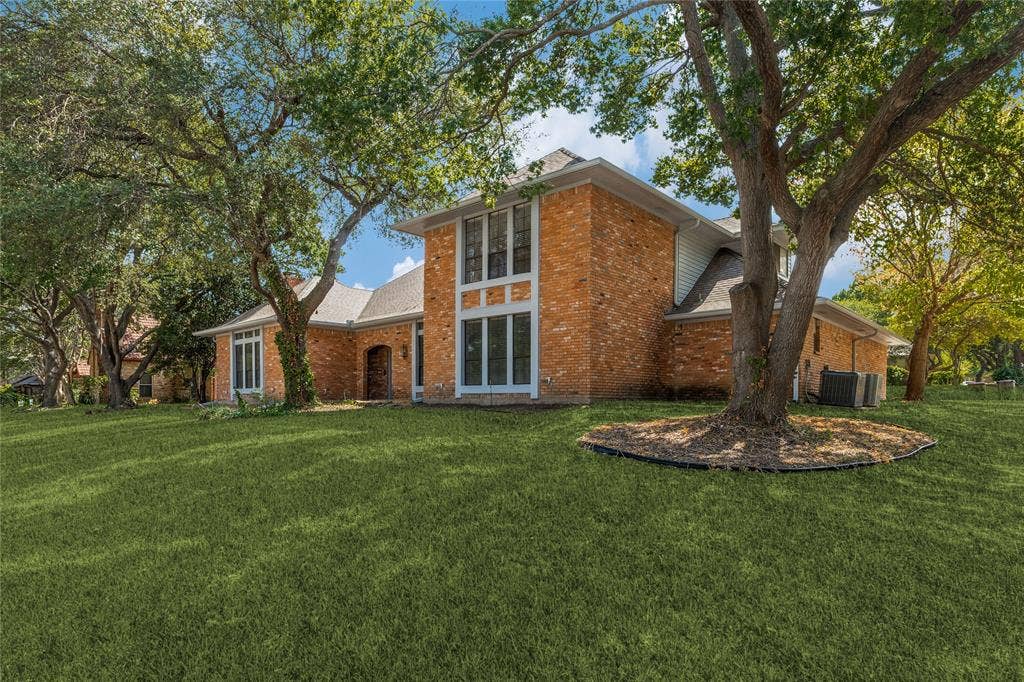 5013 Country Place Drive, Plano, TX 75023 Brick exterior with white trim, arched entryway, and mature trees providing shade.