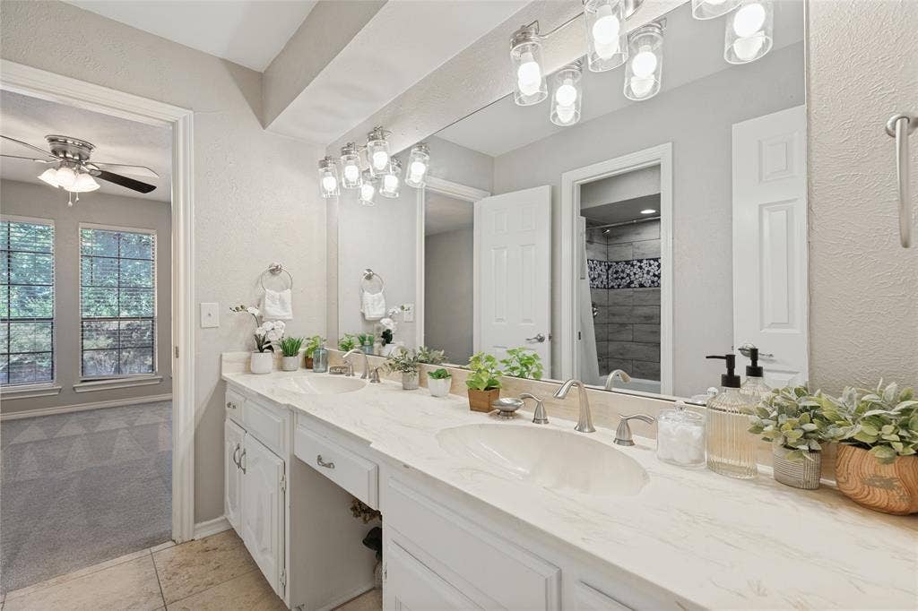 5013 Country Place Drive, Plano, TX 75023 Jack & Jill bath with Dual vanity with integrated sinks, brushed nickel fixtures, and a large wall-mounted mirror, separate toilet and bath area