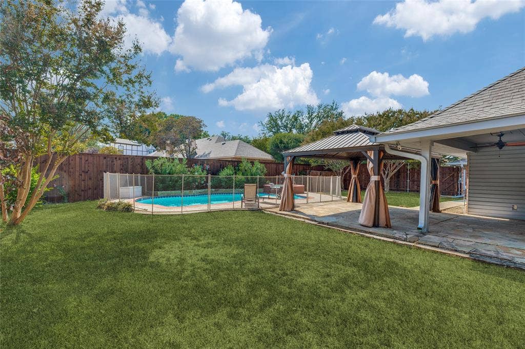 5013 Country Place Drive, Plano, TX 75023 Expansive backyard featuring a fenced swimming pool, dedicated patio area, gazebo with privacy curtains, and a covered outdoor living space, cedar privacy fence with gates