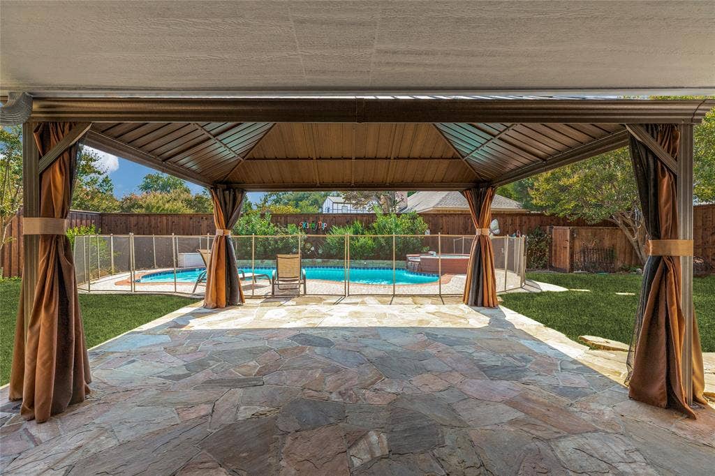 5013 Country Place Drive, Plano, TX 75023 Expansive flagstone patio with a covered gazebo featuring privacy curtains, poolside