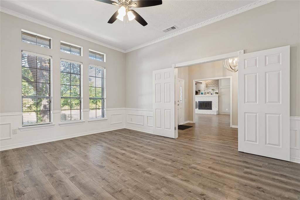 5013 Country Place Drive, Plano, TX 75023 Formal Dining room, or large office, with double entry door, amazing windows, Wood-finish flooring, picture frame wainscoting, crown molding, and a ceiling fan with light fixture