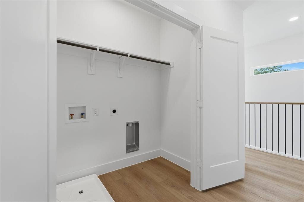 3300 S Harwood Street, Dallas, TX 75215 Laundry closet with hanging rod, water hookups, and a floor drain