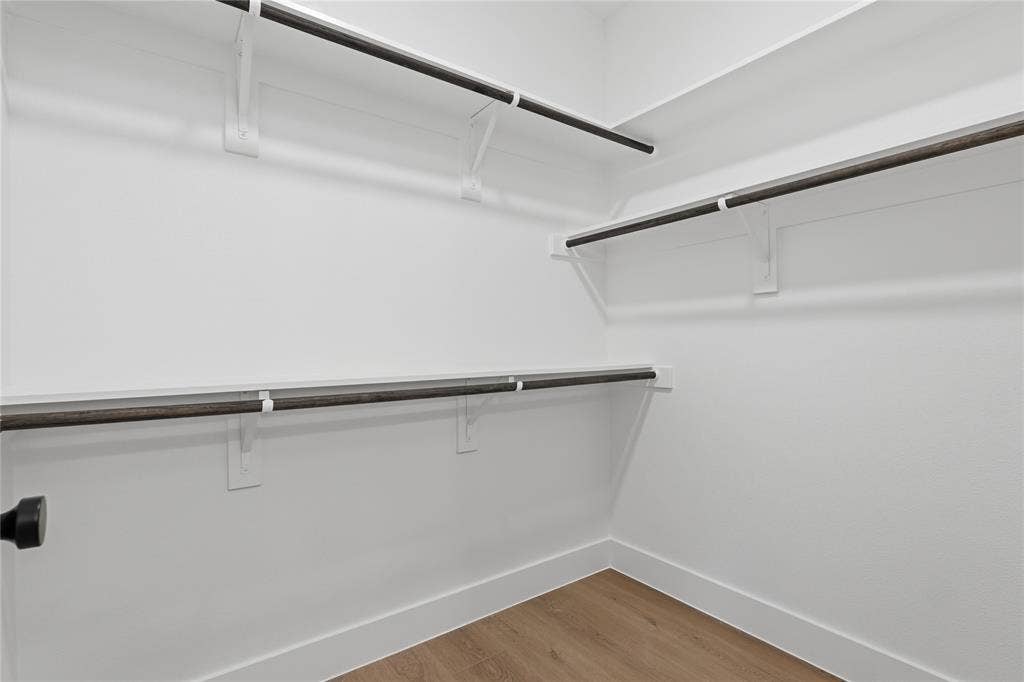 3300 S Harwood Street, Dallas, TX 75215 Walk-in closet featuring built-in shelving, hanging rods, and wood-finish flooring