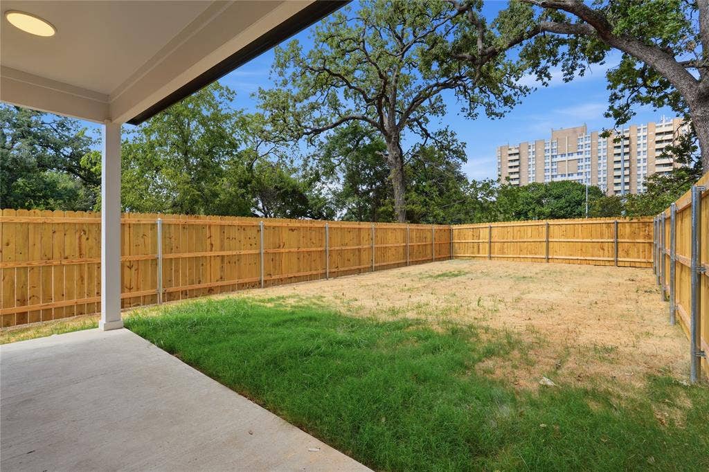 3300 S Harwood Street, Dallas, TX 75215 Covered patio with a concrete surface, enclosed by a wood privacy fence