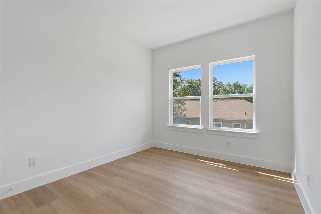 3300 S Harwood Street, Dallas, TX 75215 Wood-finish flooring, white walls, and two large windows with white trim