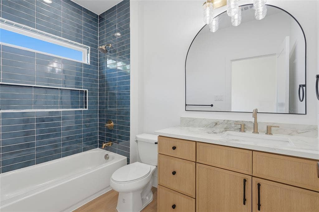 3300 S Harwood Street, Dallas, TX 75215 Contemporary bathroom featuring a wood-finish vanity with multiple drawers and brushed nickel hardware, white quartz countertop, and integrated sink