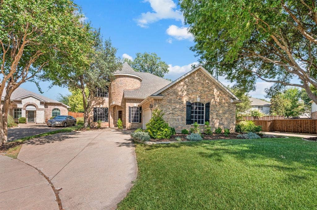 6201 Crator Drive, McKinney, TX 75070 Brick exterior with a conical turre entryt, arched windows, and decorative shutters with a swing garage and lovely front yard!