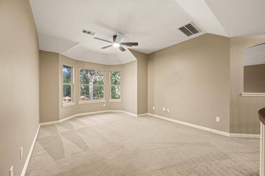6201 Crator Drive, McKinney, TX 75070 Expansive second living room or game featuring a tray ceiling, ceiling fan with integrated lighting, multiple windows, plush carpet, and freshly painted light-toned walls