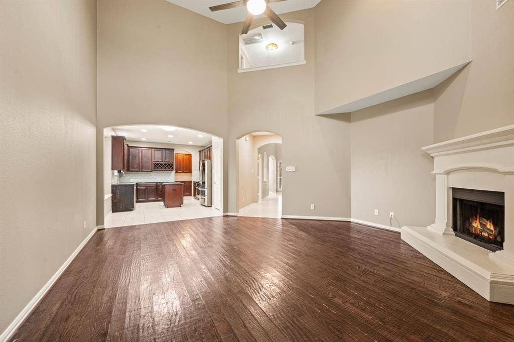 6201 Crator Drive, McKinney, TX 75070 Wood-finish flooring, vaulted ceilings, and a fireplace with a mantel, just a great space to entertain your family and friends!