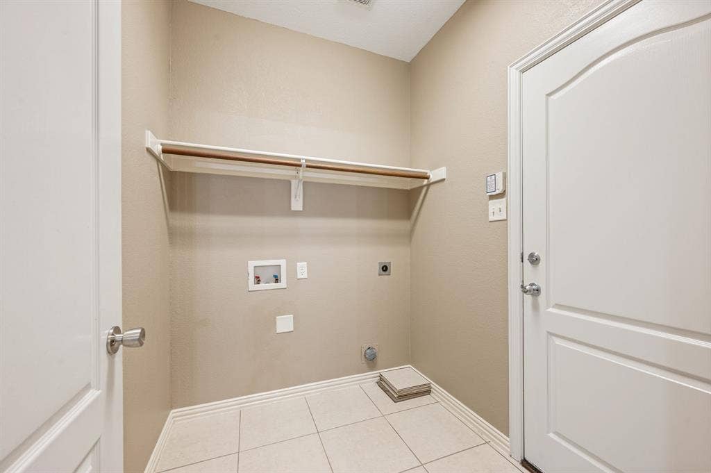 6201 Crator Drive, McKinney, TX 75070 Utility area with tile flooring, neutral wall tones, and a built-in shelving unit
