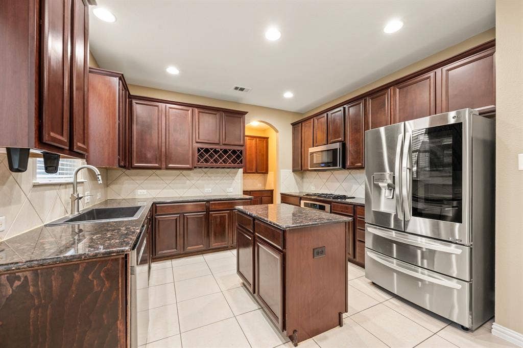 6201 Crator Drive, McKinney, TX 75070 Wonderful kitchen with wood cabinetry, granite countertops, a center island. stainless steel applilance, a butlers pantry and wonderful lighting...a great place to gather with your friends and family