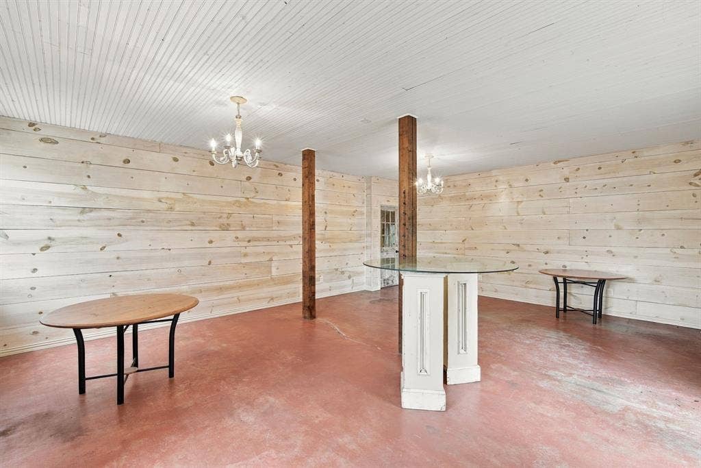 Boutique area with shiplap walls, stained concrete and 2 chandeliers.
