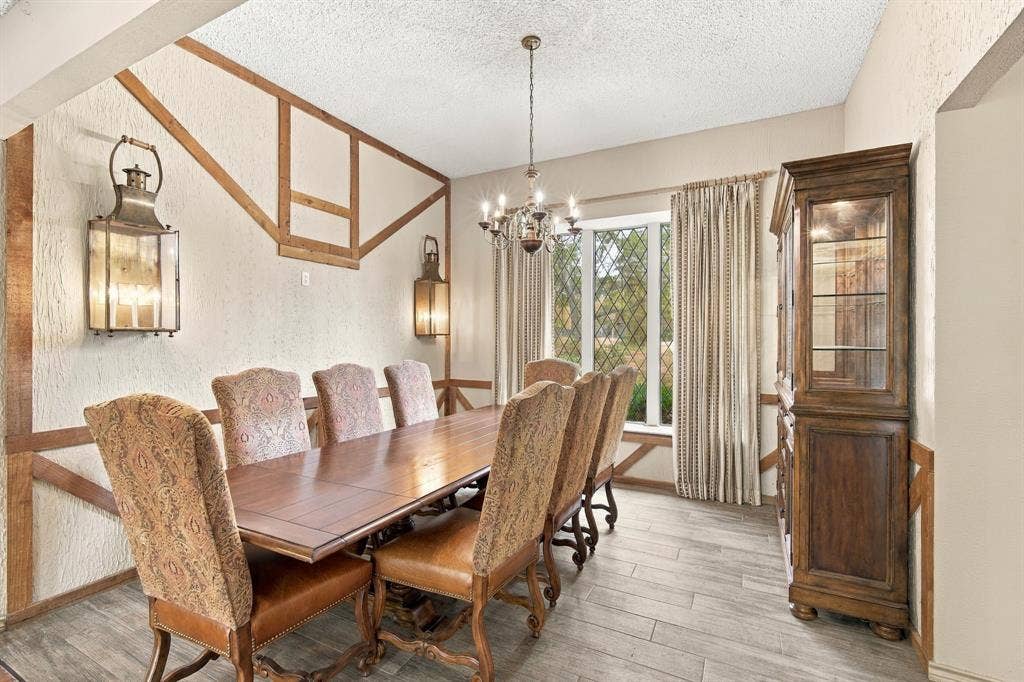 The wall trim and oversized sconces in this large dining space also add to the English Tudor style.