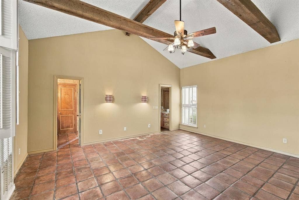 Primary Bedroom with vaulted ceiling and beams, dual vanity en suite bath with walk in closets, private office and hidden safe room.