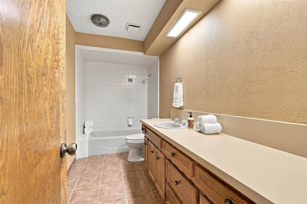 Full bath in hallway connecting to the smaller of the secondary bedrooms.