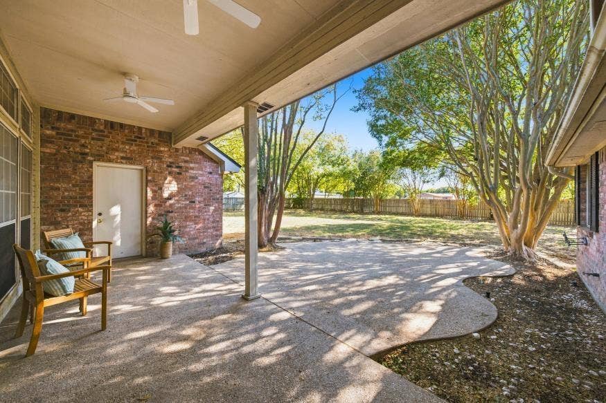 512 Meadowland Drive, Waco, TX 76657 Covered patio with dual ceiling fans, extended concrete hardscaping, brick exterior, and a spacious grassy yard