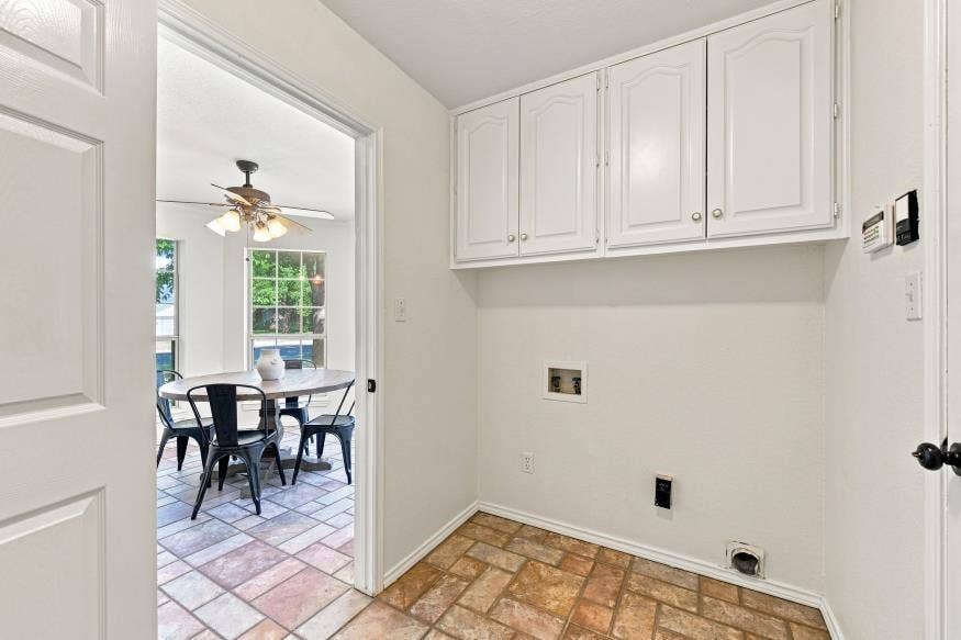 512 Meadowland Drive, Waco, TX 76657 White paneled upper cabinetry, tile flooring, and utility connections