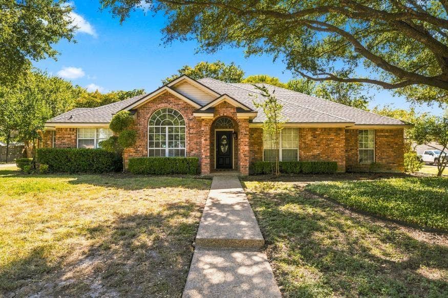 512 Meadowland Drive, Waco, TX 76657 Brick exterior with a gabled roofline, arched window, and mature trees