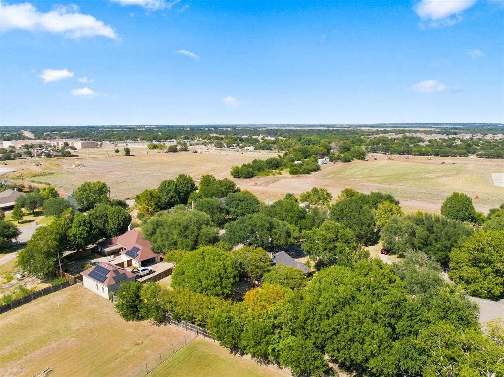 512 Meadowland Drive, Waco, TX 76657 Expansive property featuring a residence with a brown shingle roof, solar panels, and surrounding mature trees