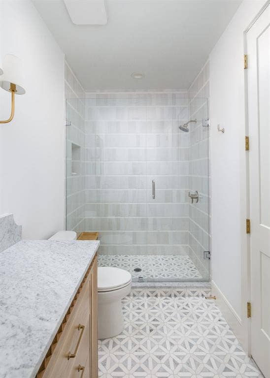 Walk-in shower with clear glass enclosure and built-in niche