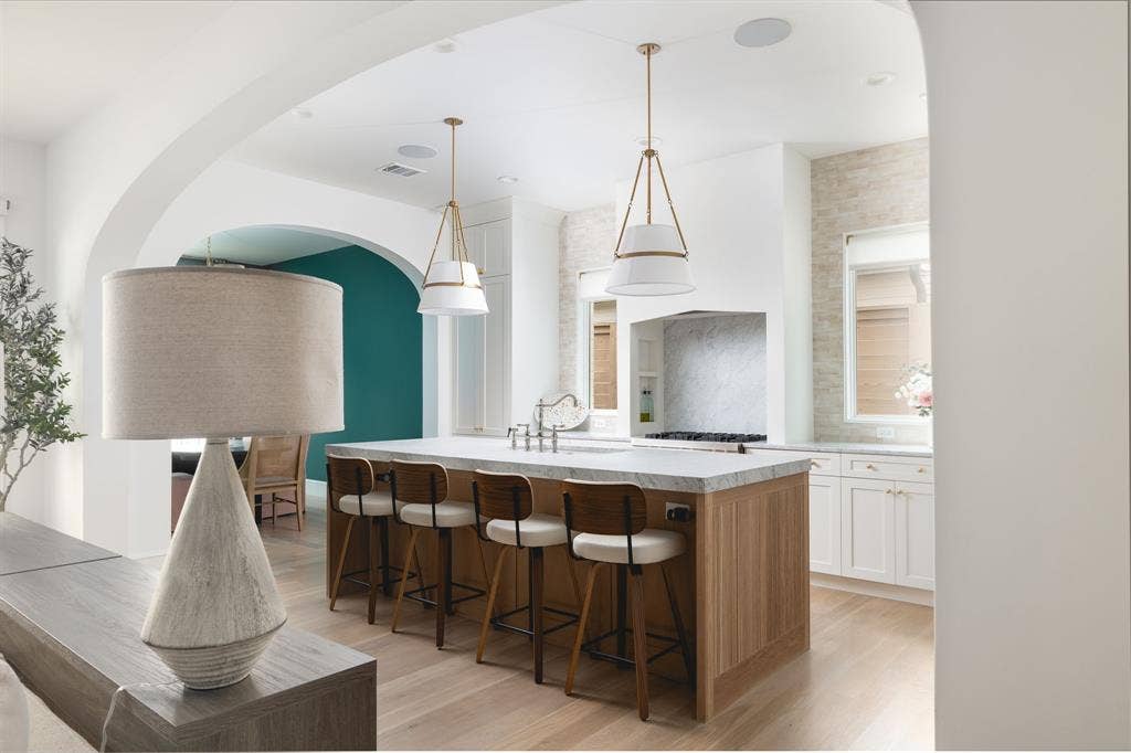 Kitchen island with a light-toned wood finish and a stone countertop