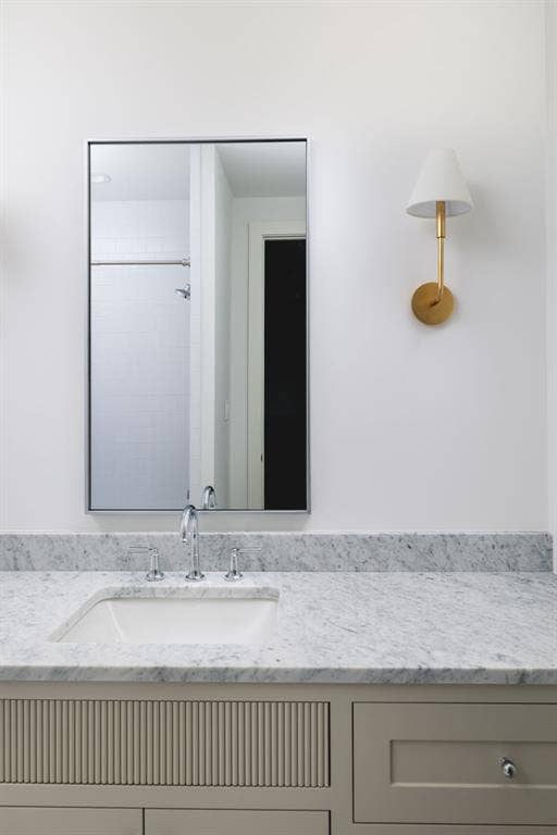 Spa-inspired bathroom vanity featuring a light stone countertop, integrated undermount sink, and polished chrome faucet