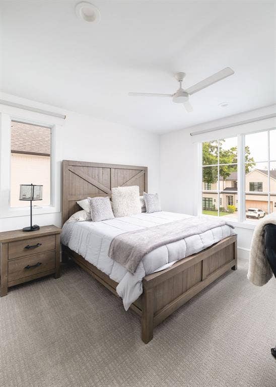 Recessed lighting, ceiling fan, and large windows with roller shades