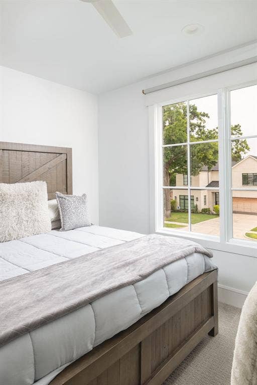 Recessed lighting, ceiling fan, and large windows with white trim