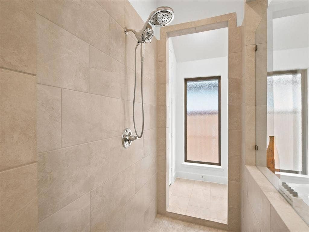 Tiled shower enclosure with a chrome-finish shower head and control