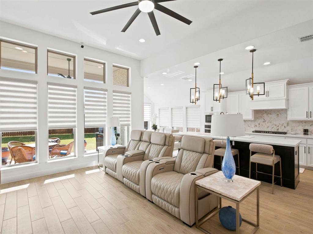 Hardwood-finish flooring, high ceilings with recessed lighting, and a contemporary ceiling fan