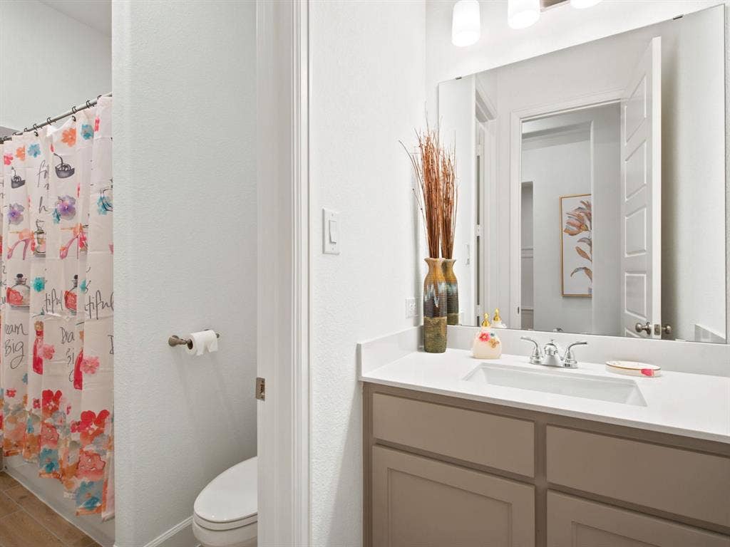 Vanity with a single undermount sink, a chrome faucet, and a light-colored countertop