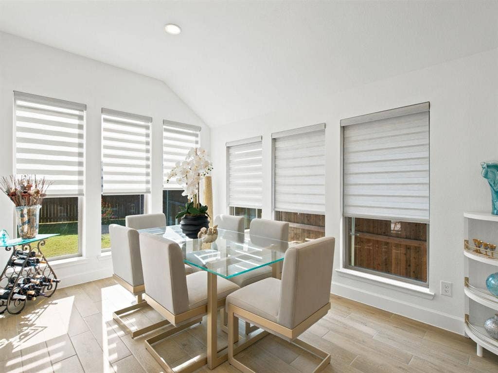 Vaulted ceiling, recessed lighting, multiple windows with blinds, wood-finish flooring, built-in shelving