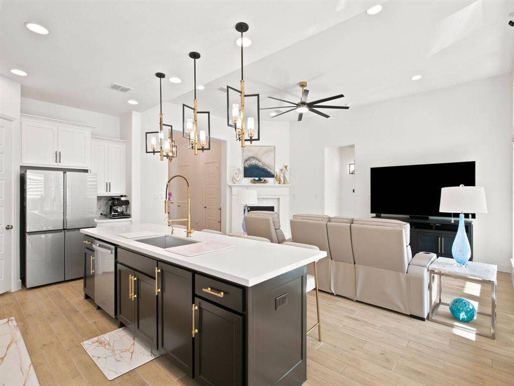 Open-concept living space with wood-finish flooring, recessed lighting, and a modern ceiling fan