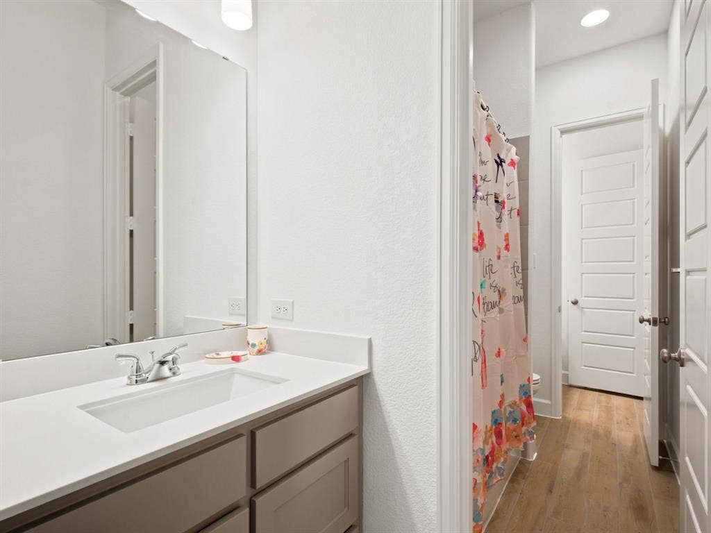 Bathroom vanity with an integrated rectangular sink, chrome faucet, and neutral cabinetry
