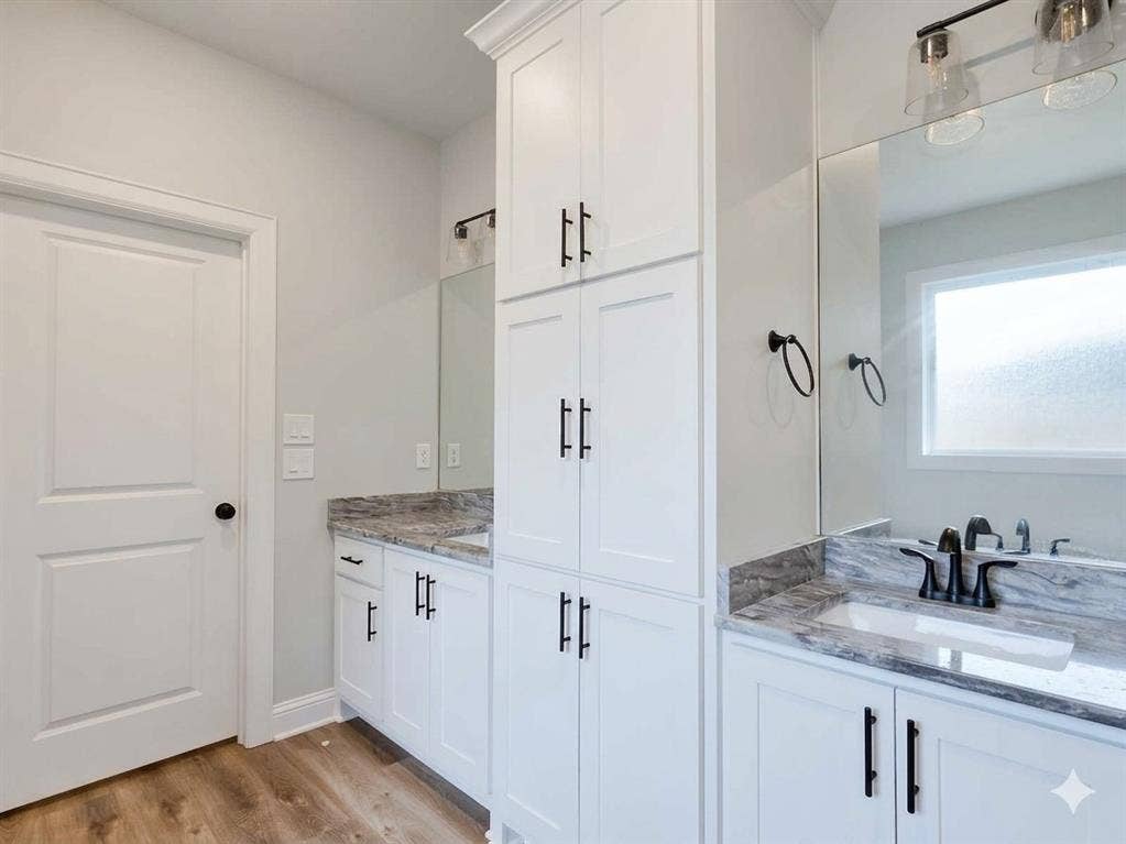 11034 Oak Springs Cove, Tyler, TX 75703 White cabinetry with matte black hardware, dual vanity with undermount sinks, stone countertops, and wood-finish flooring