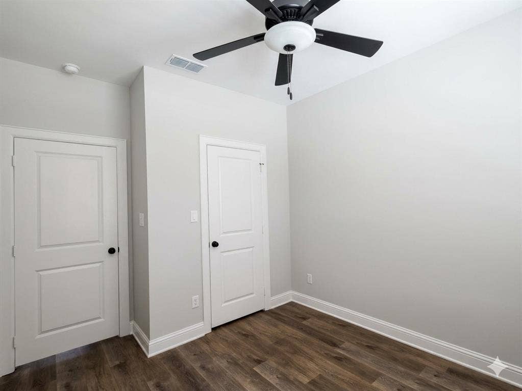 11034 Oak Springs Cove, Tyler, TX 75703 Wood-finish flooring, white trim, and a ceiling fan with light fixture