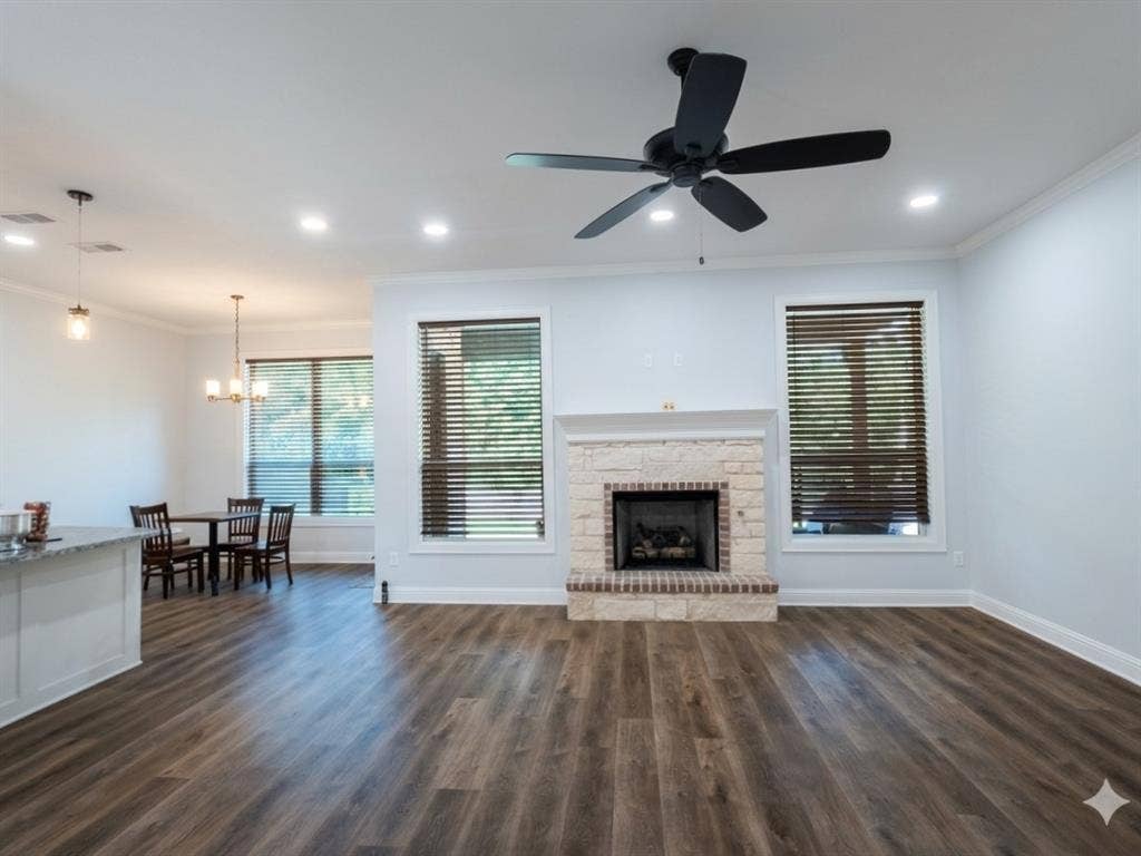 11034 Oak Springs Cove, Tyler, TX 75703 Stone-faced fireplace with brick hearth, wood-finish flooring, recessed lighting, and a ceiling fan