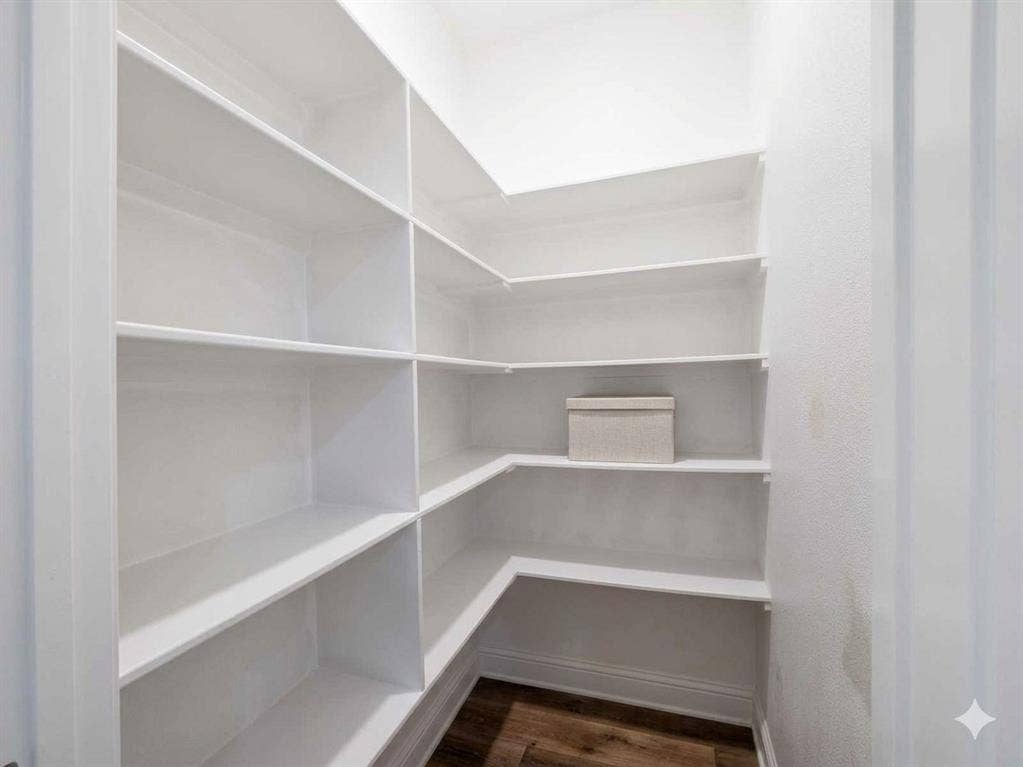 11034 Oak Springs Cove, Tyler, TX 75703 Expansive pantry with built-in shelving, wood-finish flooring, and crisp white walls