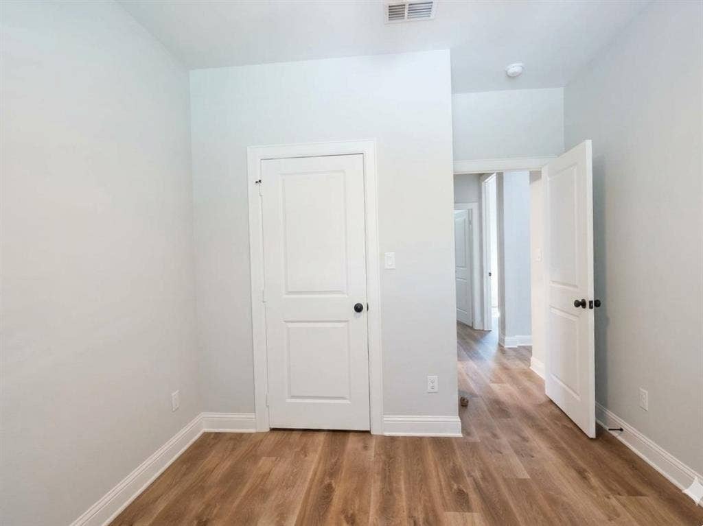 11034 Oak Springs Cove, Tyler, TX 75703 Wood-finish flooring, white doors with black hardware, and crisp white trim