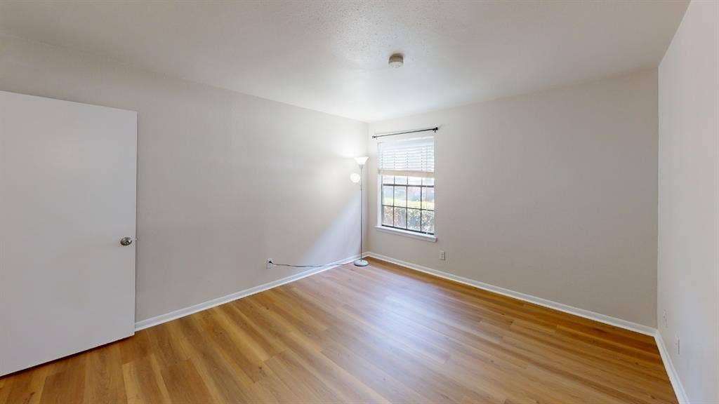 5335 Bent Tree Forest Drive, #150, Dallas, TX 75248 Wood-finish flooring with white baseboards, a window with horizontal blinds, and a white interior door