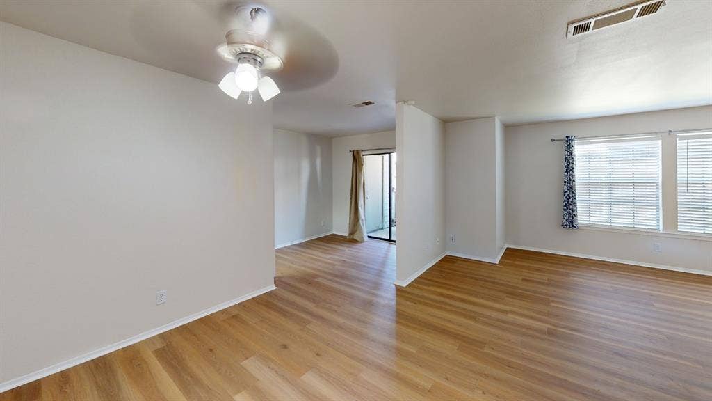 5335 Bent Tree Forest Drive, #150, Dallas, TX 75248 Spacious interior with wood-finish flooring, ceiling fan, and multiple windows with blinds