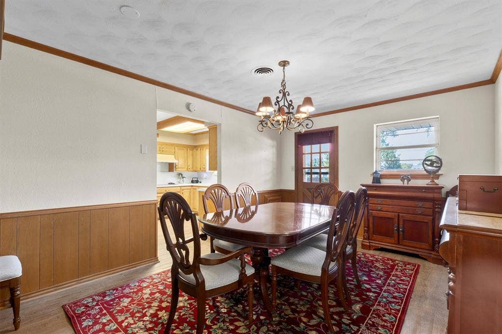 1013 Bandera Lane, Garland, TX 75040 Wood-finish flooring, wood paneling, decorative chandelier, and a transom window door