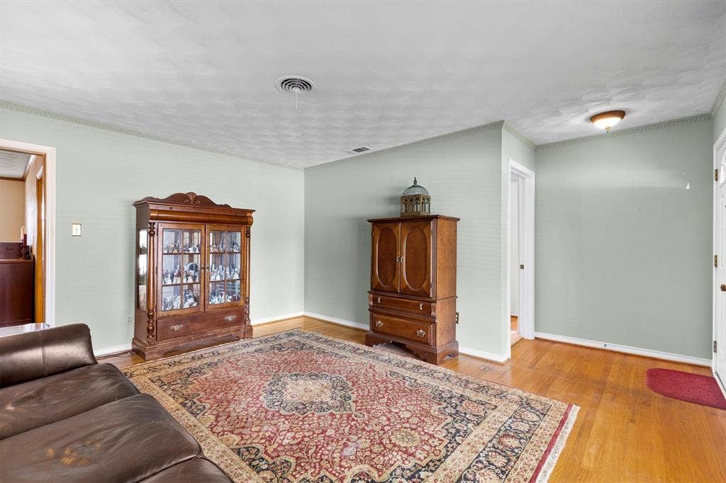 1013 Bandera Lane, Garland, TX 75040 Hardwood flooring, light-colored wall paint, white trim, and a ceiling light fixture