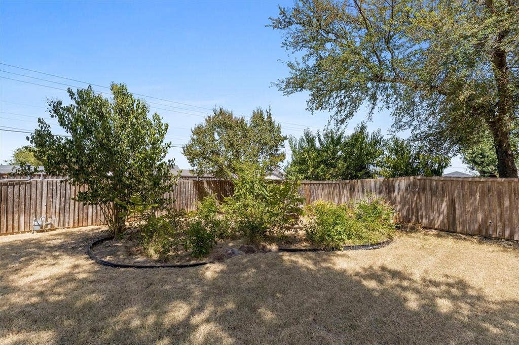 1013 Bandera Lane, Garland, TX 75040 Expansive backyard featuring a wood privacy fence and established trees