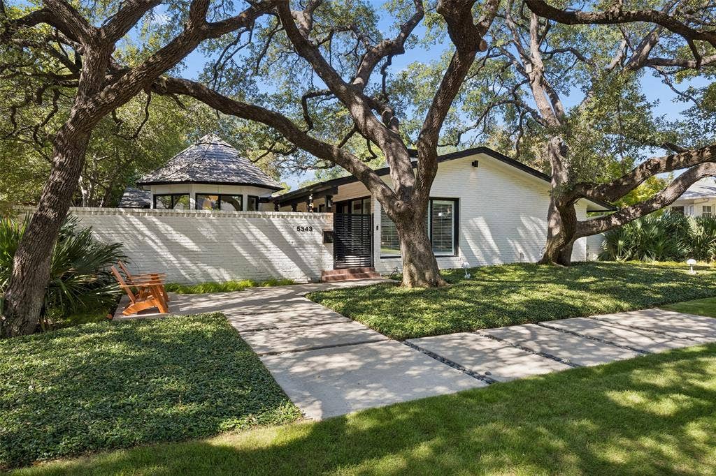 5343 Southern Avenue is a striking Mid-Century Modern residence set on an impressive 82-foot-wide lot beneath a canopy of mature trees in coveted Mockingbird Park.